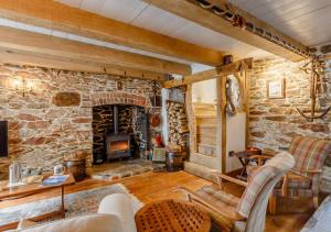 a living room with a stone wall with a fireplace at Alpha Cottage in Dittisham