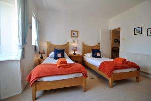 a bedroom with two beds with orange towels on them at Bayview- relaxing home by the sea in Saint Monance
