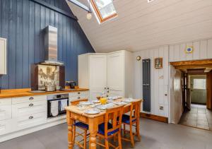 a kitchen with a wooden table in a room at Alpha Cottage in Dittisham