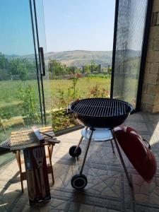 a grill in front of a window with a view at Shamakhi Nagaraxana house in Şamaxı
