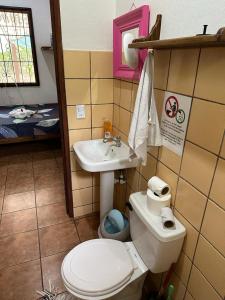 a bathroom with a toilet and a sink at Mono Azul Cahuita in Cahuita