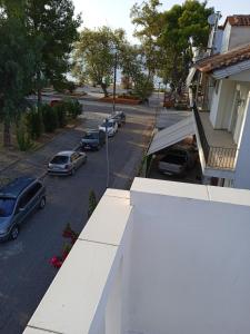 une vue aérienne sur une rue avec des voitures garées sur la route dans l'établissement Studios Θάλεια, à Neos Pirgos