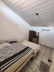 a bedroom with a bed in a white room at Barreirinhas - Chalé Tubarão in Barreirinhas