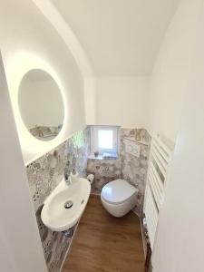 een kleine badkamer met een wastafel en een toilet bij Schönes Ferienhaus, bis 6 Pers, zentral gelegen in Heide