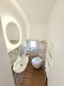 a small bathroom with a sink and a toilet at Schönes Ferienhaus, bis 6 Pers, zentral gelegen in Heide