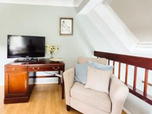 a living room with a tv and a chair at Beautiful apartment in Guildford with parking in Send