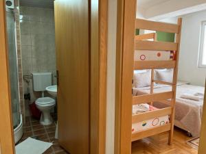 a room with a bunk bed and a bathroom with a toilet at Volkan Apartments in Ohrid