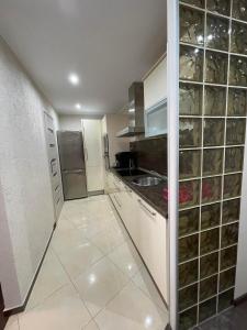La cuisine est équipée de placards blancs, d'un évier et d'un réfrigérateur. dans l'établissement Apartament CALMA I, à Krynica Morska