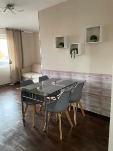 une salle à manger avec une table et des chaises en verre dans l'établissement Apartament CALMA I, à Krynica Morska