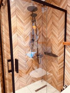 um chuveiro na casa de banho com uma parede de madeira em Casa di Arte Wood House em Perşembe