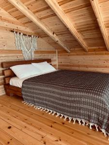 um quarto com uma cama num quarto de madeira em Casa di Arte Wood House em Perşembe