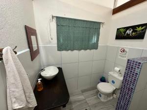 Baño pequeño con aseo y lavamanos en Mono Azul Cahuita en Cahuita