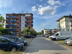 un estacionamiento con autos estacionados frente a un edificio en Apartament #RODZINNY en Rzeszów