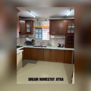 a kitchen with wooden cabinets and a white floor at Homestay Jitra Dream Homestay in Jitra