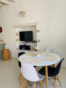 un comedor blanco con una mesa y sillas blancas en Agnanti Beach House en Pátmos