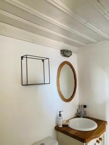 ein Bad mit einem Waschbecken und einem Wandspiegel in der Unterkunft Agnanti Beach House in Patmos