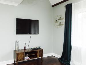 sala de estar con TV de pantalla plana en la pared en Beautiful apartment in Guildford with parking, en Send