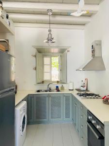a kitchen with blue cabinets and a sink at Agnanti Beach House in Patmos