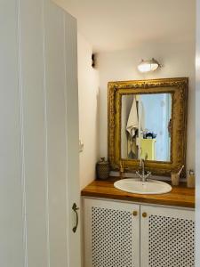 y baño con lavabo y espejo. en Agnanti Beach House, en Patmos