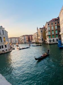 eine Gruppe von Menschen, die in Gondeln einen Kanal hinunter fahren in der Unterkunft Multiproprietà Venezia in Venedig