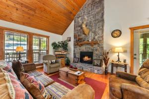 sala de estar con chimenea de piedra y muebles en Whispering Woods Lodge Home, en Branson West