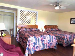 a hotel room with two beds and a chair at Lakelawn B&B and Motel in Yarmouth