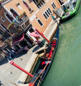 Ein Boot ist im Wasser neben einem Gebäude angedockt. in der Unterkunft Multiproprietà Venezia in Venedig
