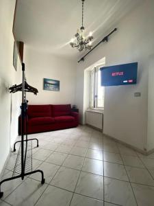 a living room with a red couch and a sign at Domus Sici in Pompei