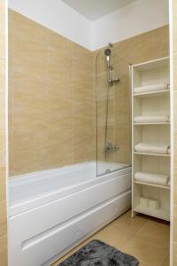 a bathroom with a tub and a glass shower at GviTown Central Apartment in Bucharest