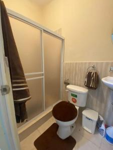 a bathroom with a toilet with a shower and a sink at Blue House - Via a la costa in Guayaquil