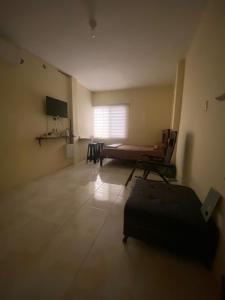 an empty room with a bed and a window at Blue House - Via a la costa in Guayaquil