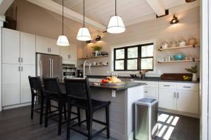 a kitchen with white cabinets and black bar stools at NEW Rustic Modern Cabin at Lutsen Mountains in Lutsen