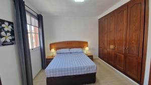 a bedroom with a bed with a wooden head board at Vivienda vacacional Lomada in San Isidro