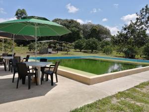 a table with an umbrella next to a swimming pool at Centro agroecoturistico las heliconias in Monterrey