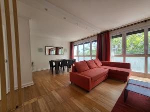 ein Wohnzimmer mit einem Sofa und einem Tisch in der Unterkunft Spacious Apartment near Paris, for Family and Friends in Montrouge