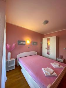 a pink bedroom with a large bed with pink sheets at Apartment Center Adria in Bar