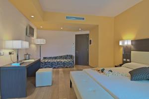 a room with a bed and a desk and a kitchen at Zen Hotel Versilia in Marina di Pietrasanta