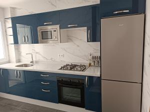 eine Küche mit blauen Schränken, einer Spüle und einem Kühlschrank in der Unterkunft The Oxygen 9 in Tétouan