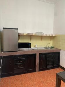a kitchen with a counter with a microwave and a sink at One Day Trip Hostel in Antigua Guatemala