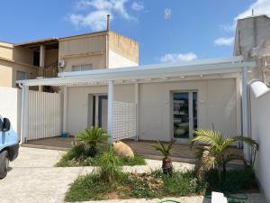 una casa blanca con palmeras delante en Da Mariano apartments, en Mazara del Vallo