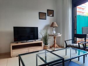 sala de estar con TV y mesa de cristal en Apartamento en Torre del Mar, en Torre del Mar