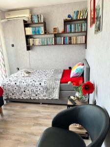 een slaapkamer met een bed en een tafel met een stoel bij Апартамент във вила Артемида in Varna
