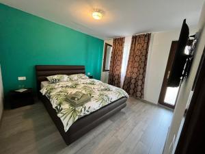 a bedroom with a bed and a green wall at Sunset Expanse in Turda