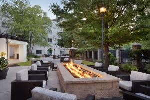 a fire pit in a courtyard with chairs and a street light at Courtyard Edison Woodbridge in Edison