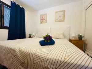 a bedroom with a bed with a bouquet of flowers on it at Apartamento Playa Grande in Tías