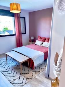 ein Schlafzimmer mit einem Bett und einem Tisch darin in der Unterkunft Grande chambre privée 18 m2 dans maison proche Gare et Nancy Thermal in Tomblaine