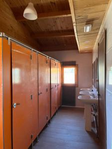 a bathroom with a row of sinks and stalls at Granja escuela con bungalows Familias y grupos Parking privado gratuito in San Martín de la Vega
