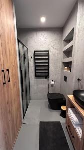 La salle de bains est pourvue de toilettes noires et d'un lavabo. dans l'établissement Mana Lake, à Sieraków