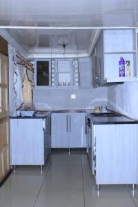 uma cozinha com armários brancos e bancadas pretas em Mutshinyalo Residence em Thohoyandou
