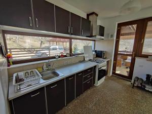 a kitchen with a sink and a stove and a window at Deleni Retreat - Casa Sitaru in Deleni